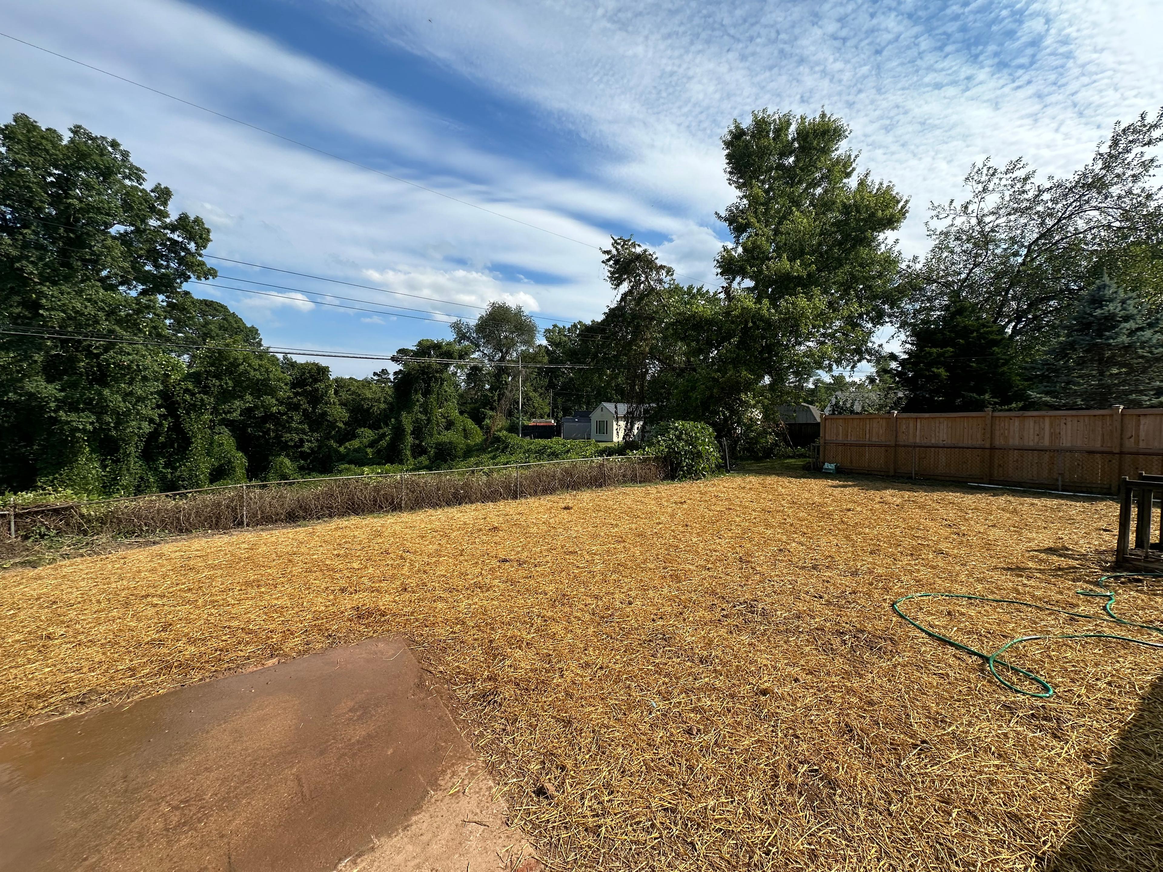 Picture of a construction crew regrading a sloped yard with heavy machinery