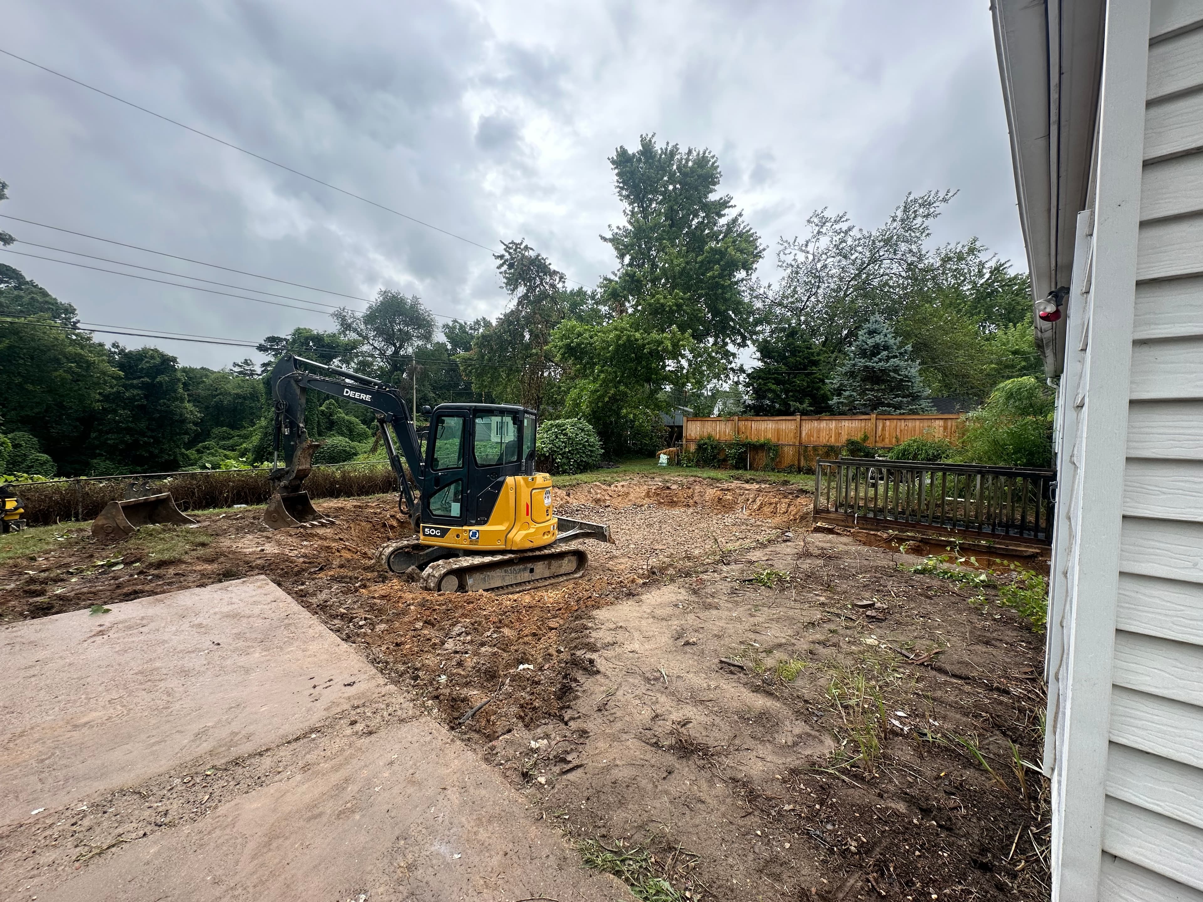 Picture of a construction crew regrading a sloped yard with heavy machinery